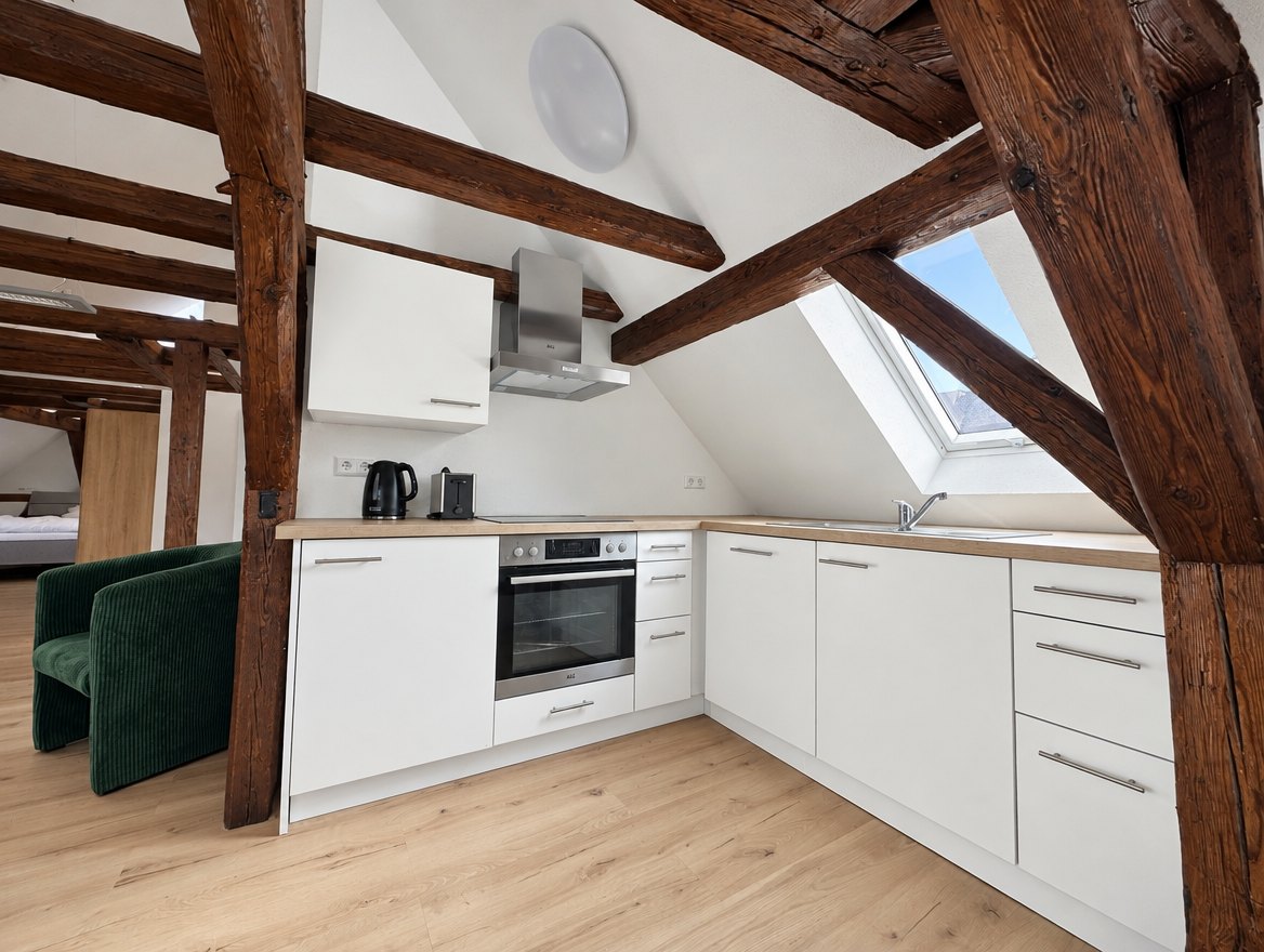 Appartement 12, Neue Straße, Einbauküche unter Holzbalken mit Dachfenster