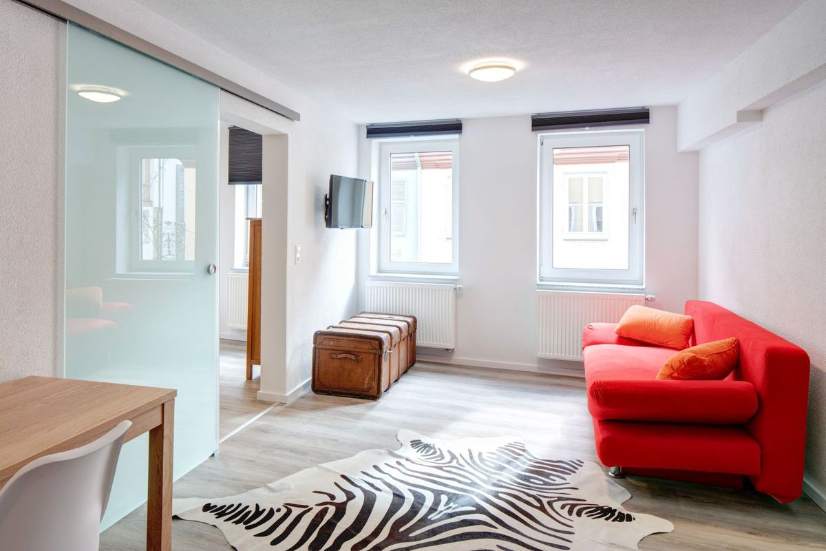 Wohnbereich mit rotem Sofa und Schiebetür
